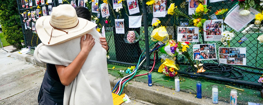 People embrace at a makeshift memorial outside St. Joseph Catholic Church in Surfside on Monday, June 28. Photo: The Associated Press