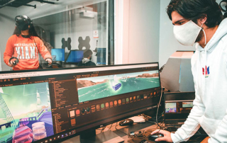 Programmer and first-year medical student Varun Krishnan edits a VR app called "Synesthesia," while its creator, University of Miami senior Léa Dorne, tests it out in the background. Photo: Mike Montero/University of Miami