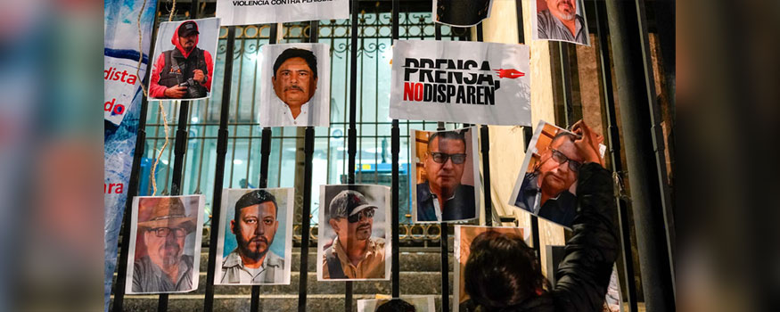 A woman posts photos of murdered journalists during a national protest against the murder of journalists in Mexico City on Jan. 25. Photo: The Associated Press